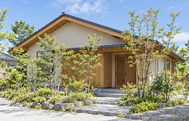 植栽に囲まれた切妻屋根の平屋の外観